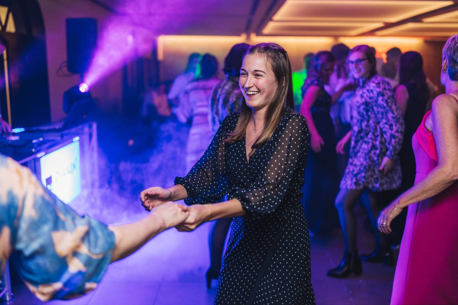 Lachende gast danst in paars licht