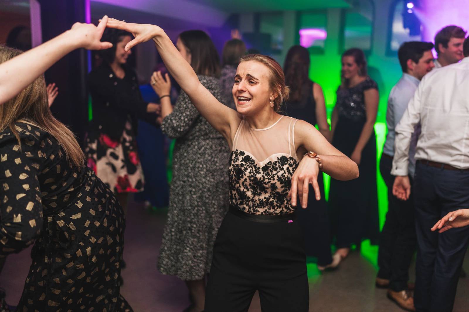 Danseres met opgeheven arm in groen licht