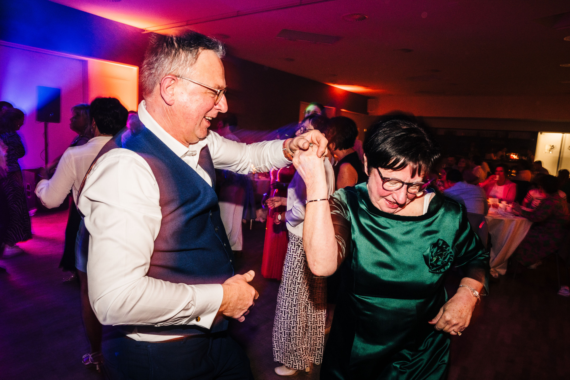 Gasten dansen samen in paars en rood licht